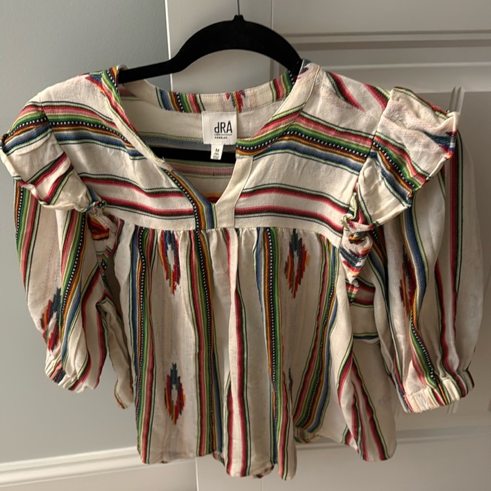 dRA blouse features a vibrant, multi-colored striped pattern